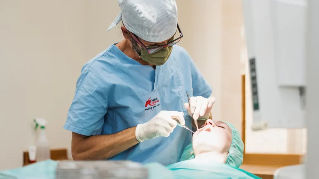Zahnuntersuchung in der Zahnarztpraxis Mathias Jahn. Das Bild zeigt Dr. Jahn wie er mit Geräten die Zähne einer Patientin untersucht. Foto: Werbeagentur IKONUM Dresden.
